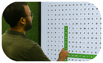 Guest playing interactive word search game at corporate event in Dubai, with branded screen, vibrant green backdrop